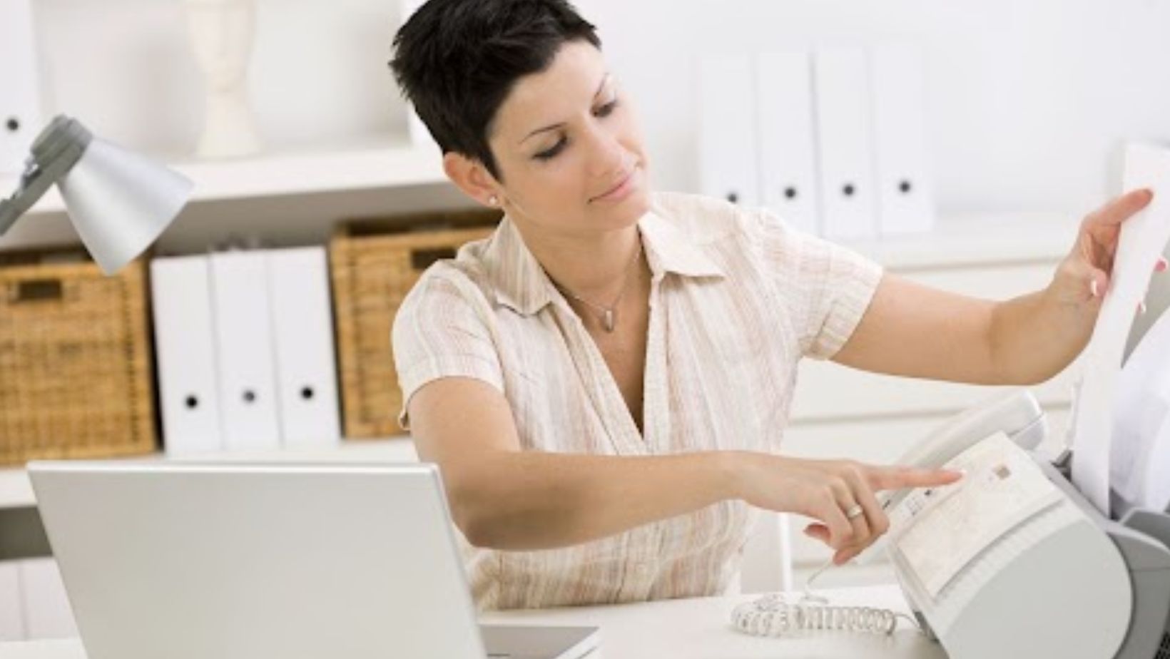 Employee using cloud faxing solutions to email clients seamlessly.