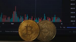 A Bitcoin and Ethereum coin placed in front of a cryptocurrency market chart